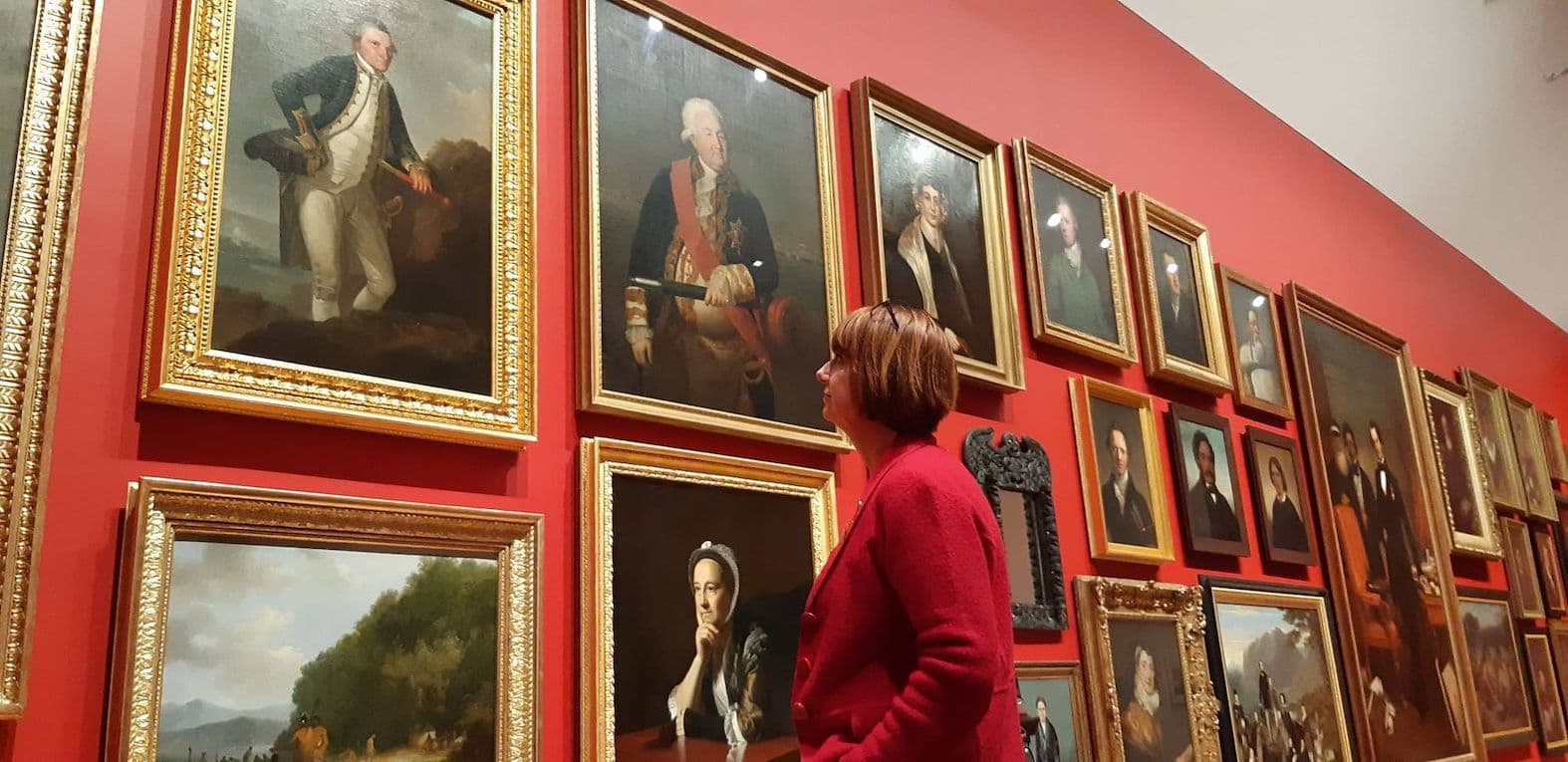 Karen Stade admiring books to use for historical writing on a library wall